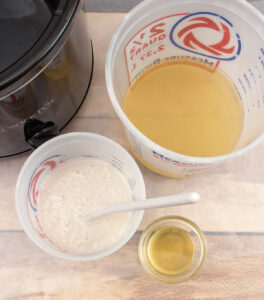 three containers with a foamy liquid, a light brown liquid, and an oil